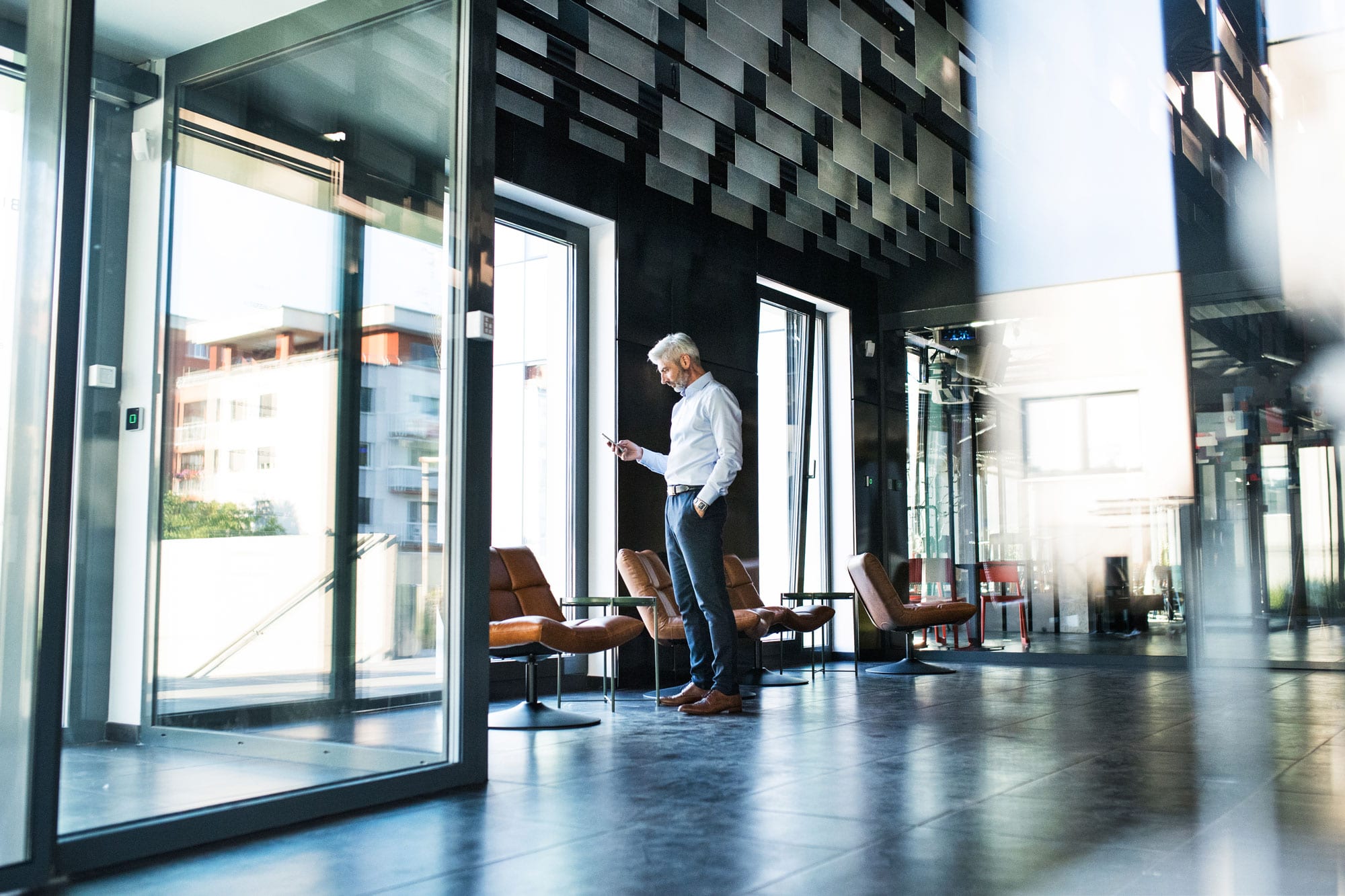 mature-businessman-with-smartphone-in-the-office-P8PW5TC